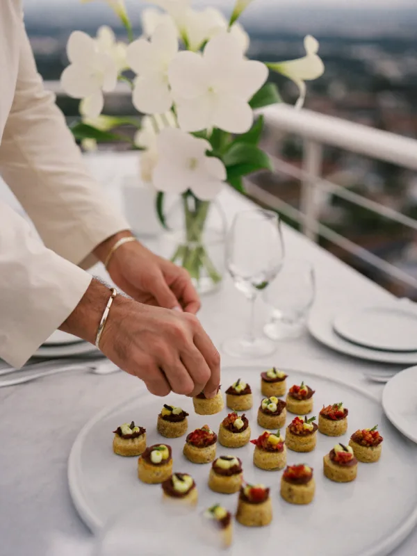 Mesero acomodando canapés en un evento elegante